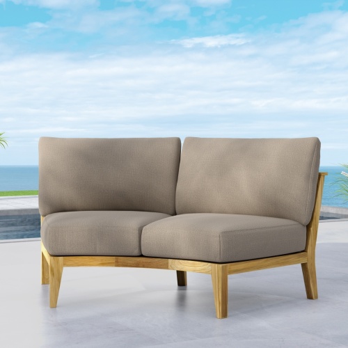 13343DP Kafelonia Sofa Sectional with optional cushions angled front view on outdoor patio with ocean and blue sky background background