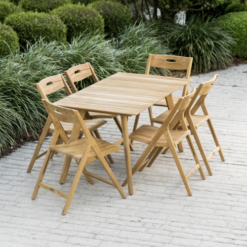 70518 Surf 7 piece teak folding Dining Set on paver patio with landscape plants and shrubs in background in aerial view