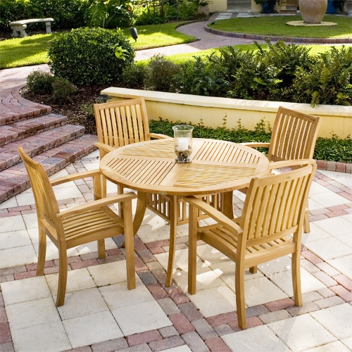 70027 Grand Hyatt 5 piece Dining Set with candle and glass holder on table on brick patio in front of concrete planter of landscape plants a walkway with grass and shrubs in background