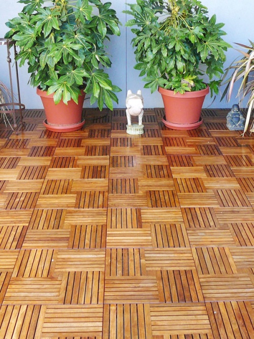 18412P Parquet Teak Tiles assembled on a condo deck with 2 potted plants against wall in background