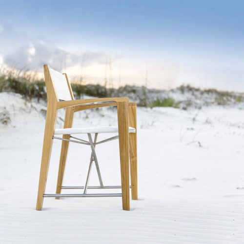 12915F Odyssey Director Chair right side view facing ocean on sandy beach with sand dunes and sea grass and blue sky in background