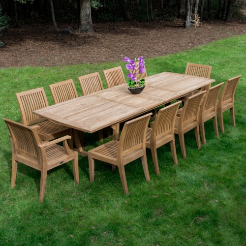 12810 Laguna Dining Armchair showing 10 around Teak Rectangular Table on a grass lawn with landscape trees in the background 